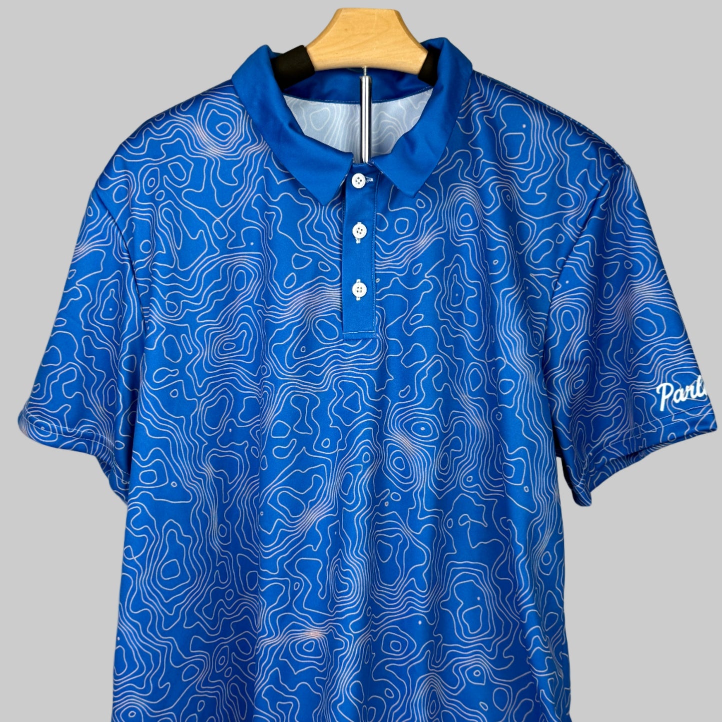 Blue patterned polo shirt on a hanger against a white background